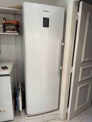 a white refrigerator in the corner of a room