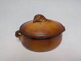 un petit pot marron surmonté d'une feuille
