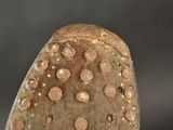 a stone with holes on it on a black surface