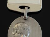 une image représentant une médaille d'argent sur laquelle figure le visage d'une femme