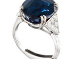 a close up of a blue sapphire and diamond ring on a white background