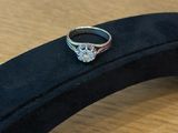 une bague en argent sertie d'un diamant, posée sur un écrin noir