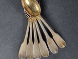 five spoons and a spoon rest on a black surface
