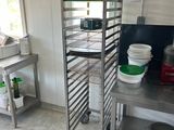 a metal rack with several pans on it in a kitchen
