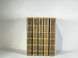three books are stacked on top of each other on a white surface