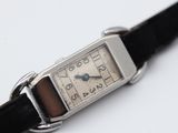 a silver watch with a black strap on a white surface