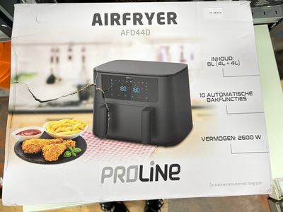 une friteuse à air chaud posée sur une table, à côté d'une assiette de nourriture