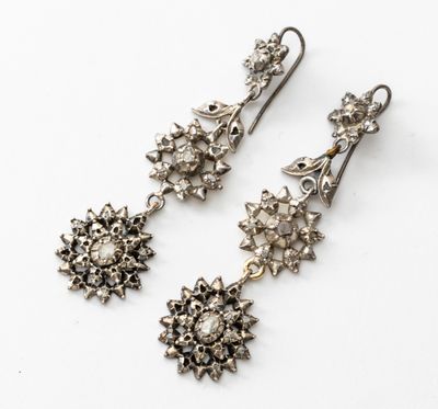 une paire de boucles d'oreilles anciennes en argent et diamants sur fond blanc