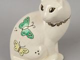 un chat blanc avec des papillons verts sur la poitrine