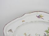a white plate with birds and flowers painted on it