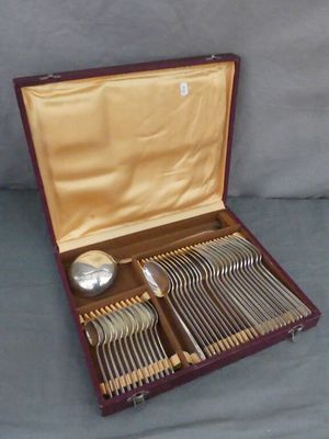 des couverts dans un coffret en bois posé sur une surface grise
