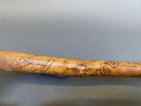 a wooden stick with writing on it sitting on a table