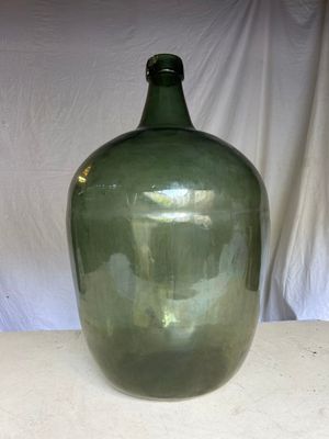 a large green glass bottle sitting on a table