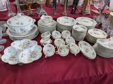 plusieurs assiettes et tasses sur une table avec une nappe rouge