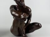 sculpture représentant une femme assise par terre, les mains posées sur les genoux