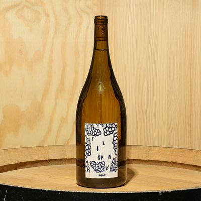 a bottle of wine sitting on top of a barrel