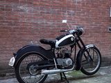 a black motorcycle parked in front of a brick building