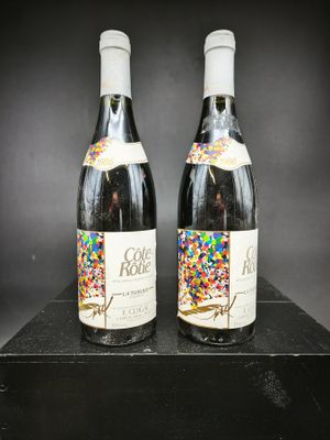 deux bouteilles de vin décorées de paillettes, posées sur une table