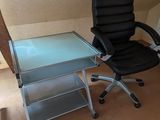 un bureau avec une chaise et une table à plateau en verre