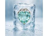 an ice cube with a heart shaped aqua blue topaz surrounded by diamonds