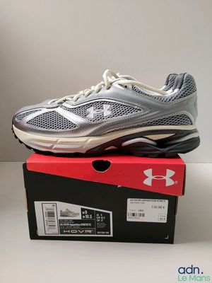 Les chaussures Under Armour se trouvent dans une boîte posée sur une table.