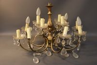 Lustre à douze bras de lumière en métal doré et pampilles en…