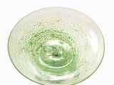 a green glass bowl sitting on top of a white table