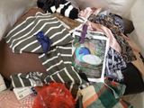 a pile of clothes and other items on a bed