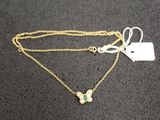 a gold necklace with a butterfly charm on it