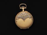 an antique gold pocket watch on a black background with a black background
