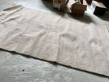 un grand tapis posé à même le sol, à côté d'une pile de cartons