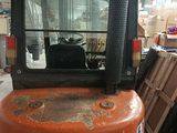 an orange forklift truck parked inside of a warehouse