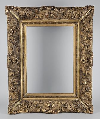 un miroir orné d'un cadre doré au motif floral