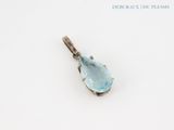 a close up of a blue topaz stone pendant on a white surface