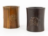 paire de vases en bois ornés de motifs sculptés sur un fond blanc