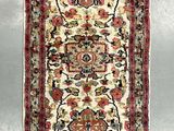 an antique persian rug with a floral design on a white ground