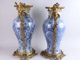 pair of blue and white vases with gold handles on a white background