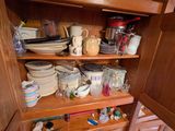 un placard rempli d'assiettes et de tasses dans la cuisine
