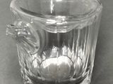 a small glass cup with a handle on a table