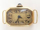 a small gold watch with roman numerals on the face