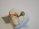 a ring on a ring holder with a red string