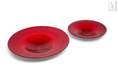 deux assiettes rouges posées sur une surface blanche, sur fond blanc