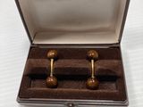 pair of wooden cufflinks in a box on a white surface
