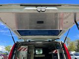 a red van with the back door open in a parking lot