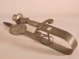 a metal object that has a knife and a sword on it