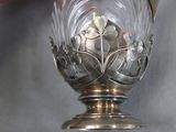 a silver vase with flowers on it on a table