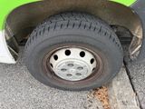 a close up of a tire on the side of a green bus