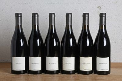 six bouteilles de vin sont alignées sur une table en bois