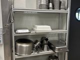 de nombreuses casseroles et poêles sur les étagères de la cuisine