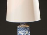 a blue and white table lamp with a white shade on it